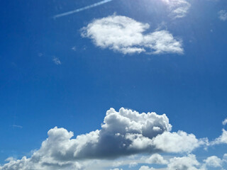 White fluffy cumulus clouds background. Summer clouds in the blue sky