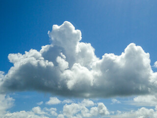 Naklejka na ściany i meble White fluffy cumulus clouds background. Summer clouds in the blue sky