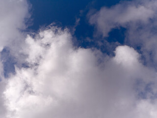 White fluffy cumulus clouds in the summer sky, natural clouds background