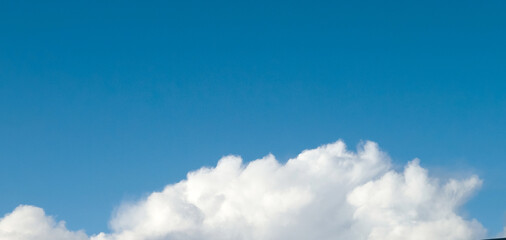 White fluffy cumulus clouds in the summer sky, natural clouds background