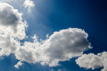 Blue sky with white clouds in sun rays