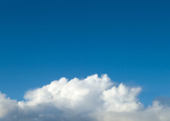 White fluffy cumulus clouds in the summer sky, natural clouds background