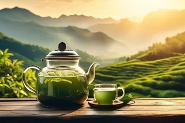  Black tea infuser tea against a background of green tea plantations and mountains. With copy space © Margarita