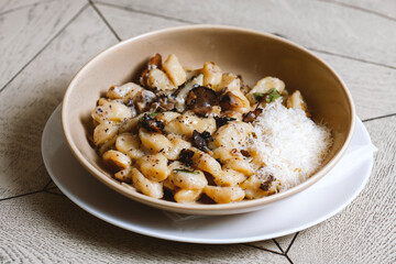 Pappardelle pasta with mushrooms and parmesan cheese on a plate . Traditional Italian gnocchi pasta with mushroom and parmesan cheese