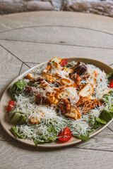 Crispy chicken salad with parmesan cheese and cherry tomatoes . Caesar salad
