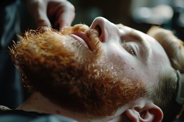 Naklejka premium Man reclining in a chair while receiving a beard trim