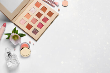 Different makeup products and beautiful flower on white background with space for text, flat lay. Bokeh effect