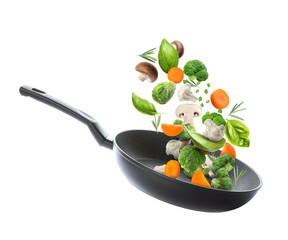 Frying pan with fresh ingredients in air on white background