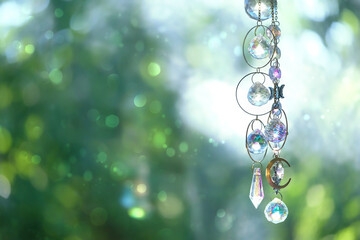 Crystal prism on abstract blurred natural background. Magic Ritual with crystal sun catcher. practice for positive spirit, harmony, relax, productive the mind. Witchcraft. Feng Shui. copy space