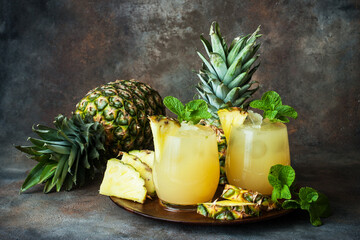 Pineapple fresh juice drink in glasses and ripe pineapple fruit