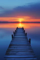 Foto op Canvas The warm glow of dawn bathes a lakeside jetty, with serene waters and reeds framing the rising sun. © burntime555