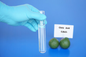Hand in blue glove hold glass  test tube  to do science experiment about Citric Acid with molecular...