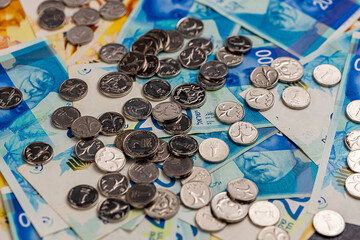 New Israeli shekel coins and bills lie on the table. Shekels. - obrazy, fototapety, plakaty