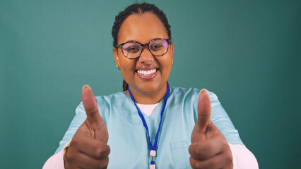 Young Black female nurse excitedly shows thumbs up while smiling