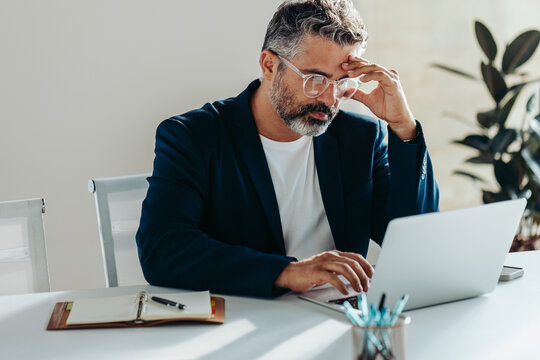 Stressed businessman facing work challenges at the office