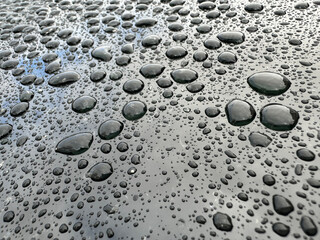 A wet surface with many small water droplets scattered across it