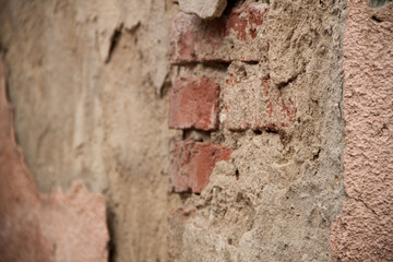 Texture of an old ragged wall. Background of old bricks and cracks in plaster. Yellow and brown tones
