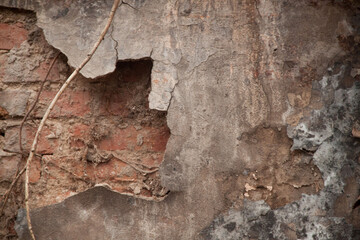 Texture of an old ragged wall. Background of old bricks and cracks in plaster. Yellow and brown tones