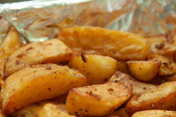 Baked potatoes in foil. Food delivery. Texture of baked potatoes with skin