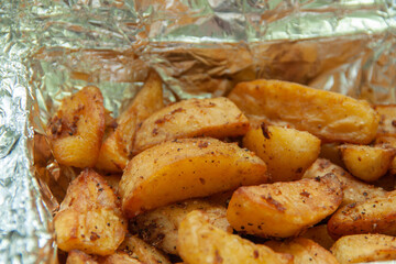 Baked potatoes in foil. Food delivery. Texture of baked potatoes with skin