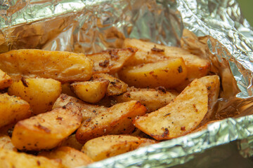 Baked potatoes in foil. Food delivery. Texture of baked potatoes with skin