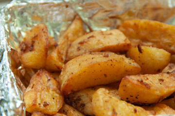 Baked potatoes in foil. Food delivery. Texture of baked potatoes with skin