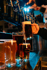 Fototapeta na wymiar Taps pouring beer in pub, with variety of light and dark beer or ale glasses showcasing different brews. Serving craft beer from tap. Concept of alcohol drinks, nightlife, festivals, Oktoberfest. Ad
