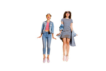 Obraz premium Full legs length body size two funny funky glad positive grinning cheerful charming friendly optimist lady in glasses spectacles casual denim jeans outfit jump isolated on yellow bright background