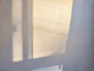 Soft Shadow of a Window Frame Cast on a White Wall. Partial focus, blurred picture. Background,...