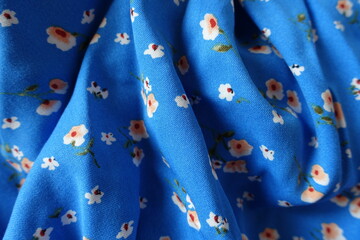 Folded vibrant blue cotton fabric with old fashioned floral print