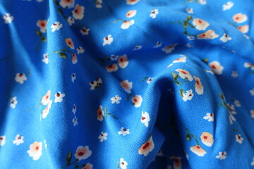 Rumpled vibrant blue cotton fabric with old fashioned floral print