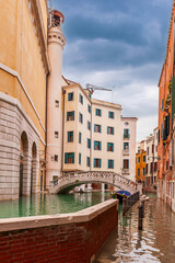 The acqua alta raises the water of a canal, in Venice, Veneto, Italy - 773907981