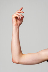 Elevated Bare Human Arm Bent at the Elbow Against a Neutral Background