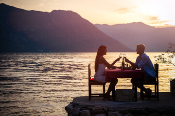 Couple is having a private event dinner on a tropical beach during sunset time