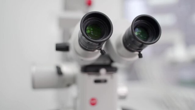 Close-up shot of microscope eyepiece tube in modern medical research laboratory. Modern equipment for scientists work in the genetics lab, biotechnology. Dental microscope in stomatology clinic.