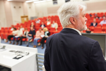 Orator on stage discussing with audience during business conference