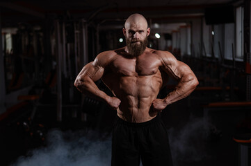 Fototapeta na wymiar Caucasian bald man posing in the gym.