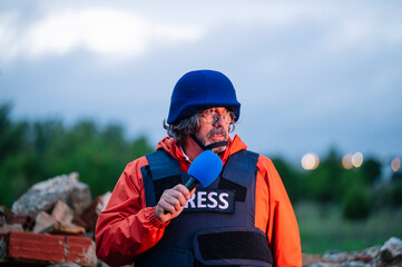 Press reporter in bulletproof vest holding a microphone.