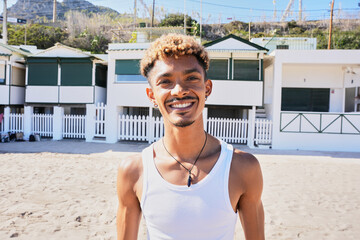Portrait of happy young Latin man smiling looking at the camera on the beach. Holidays lifestyle of...