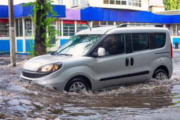Waterlogged Car: Vehicle Struggling in Flooded Area - 773934550