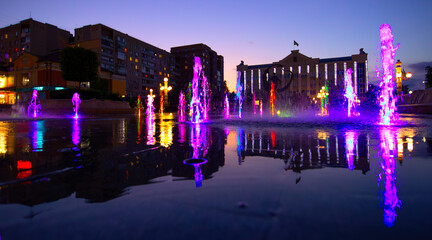 Nighttime Oasis: Fountain Glows in the Evening Illumination - 773934730