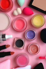 Various colorful beauty products on bright pink background. Top view.