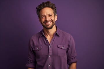 Obraz premium A man is smiling and wearing a purple shirt