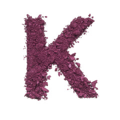 Stencil capital letter K made by burgundy crushed eye shadow or broken powder isolated on white background.