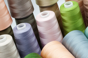 Thread spools background. Various colors sewing kit. Collection of threads. Pale pastel colors. Sew threads. Colorful hobby background. Tailor shop texture. Isolated on white.