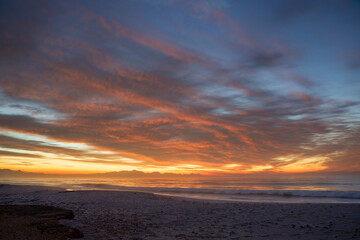 Obraz premium Beautiful Sunrise Morning Over Beach And Sea Looking Towards Mountains In South Africa