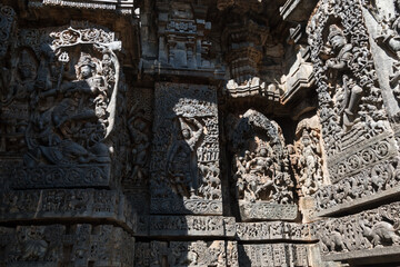 Ornate carvings of Hindu deities on the walls of the ancient Hoysaleswara temple in Halebidu. - obrazy, fototapety, plakaty