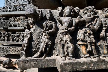 Close up detail of beautiful carvings of dancing figurines on the wall of the ancient Hoysaleshwara temple in Halebidu. - obrazy, fototapety, plakaty