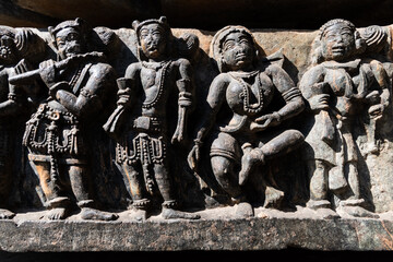 Close up detail of beautiful carvings of dancing figurines on the wall of the ancient Hoysaleshwara temple in Halebidu.