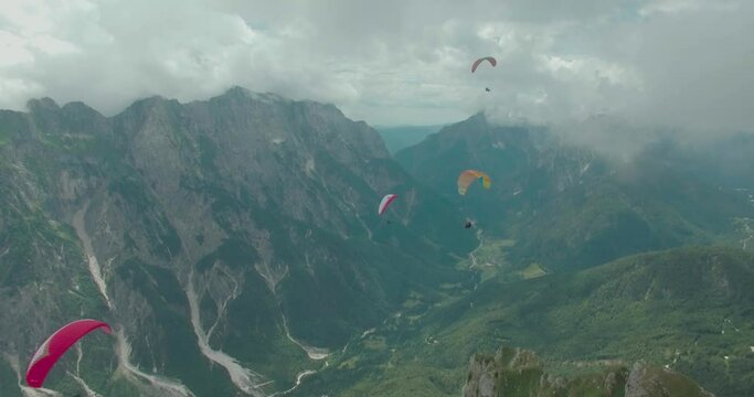 paragliders circling in the sky above the beautiful mountains